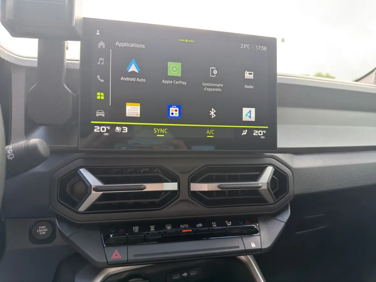 Vue rapprochée du tableau de bord du Dacia Bigster Journey hybride 2025, écran tactile multifonctions et commandes climatisation visibles.