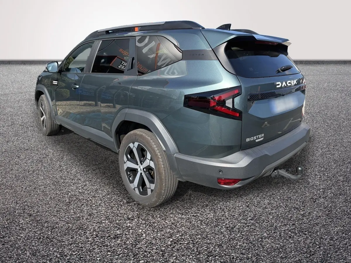 Vue 3/4 arrière droite d'un Dacia Bigster vert avec attelage et feux arrière LED distinctifs.