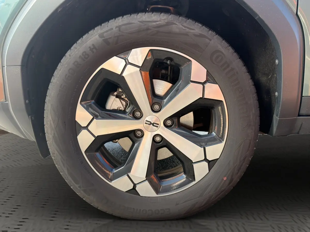 Gros plan sur la roue avant droite du Dacia Bigster vert avec jante alliage bicolore et pneu Continental.