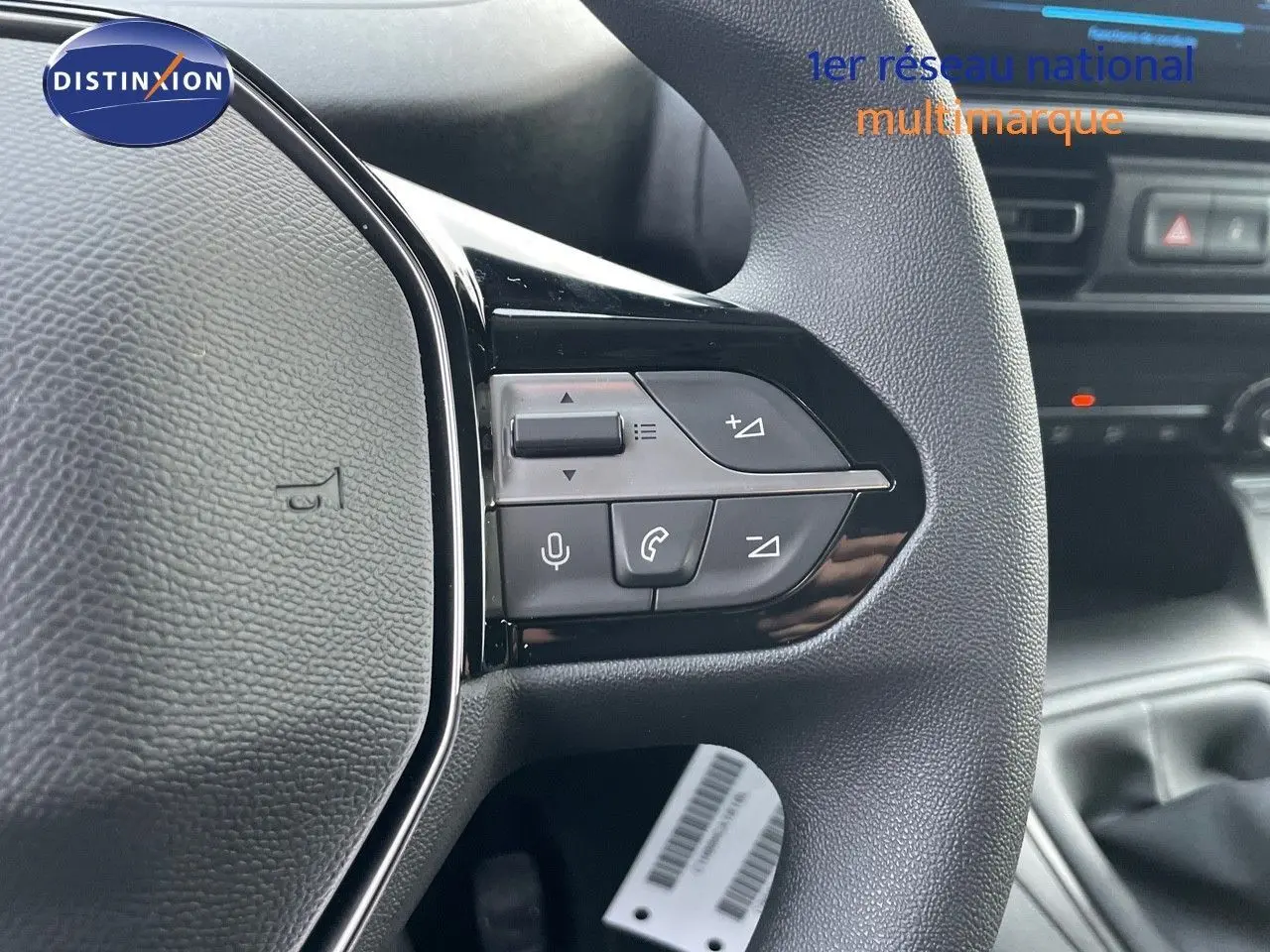 Gros plan sur le volant noir du Peugeot Partner 2025 avec commandes audio et téléphone intégrées.