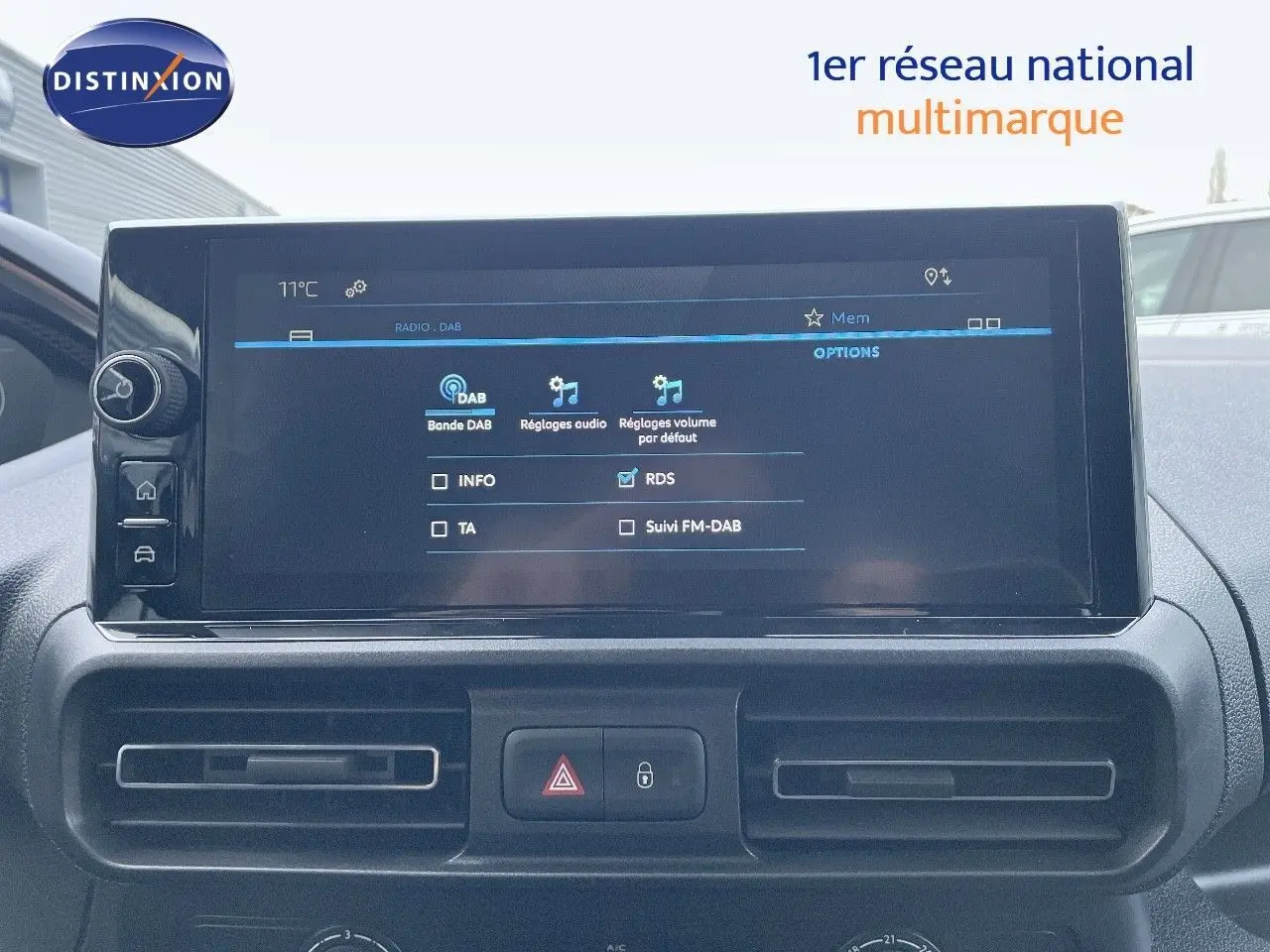 Écran tactile central du tableau de bord du Peugeot Partner 2025, affichant les réglages audio DAB, avec commandes et aérateurs noirs.