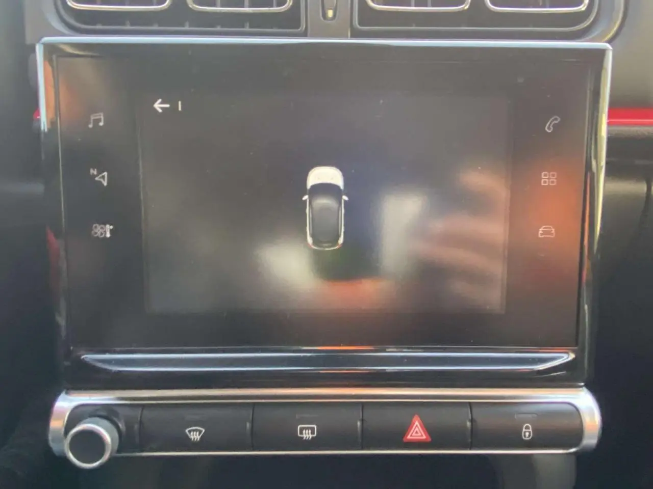 Écran tactile central de la Citroën C3 2017 affichant l'aide au stationnement avec vue du dessus du véhicule noir toit rouge.