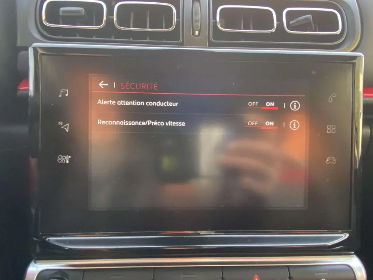 Gros plan sur l'écran tactile central du Citroën C3 noir toit rouge, affichant les réglages de sécurité du conducteur.