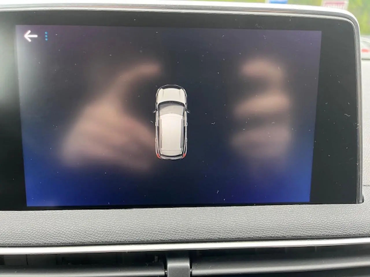 Écran tactile intérieur affichant la vue aérienne du Peugeot 3008 gris Amazonite, avec tableau de bord en cuir gris.