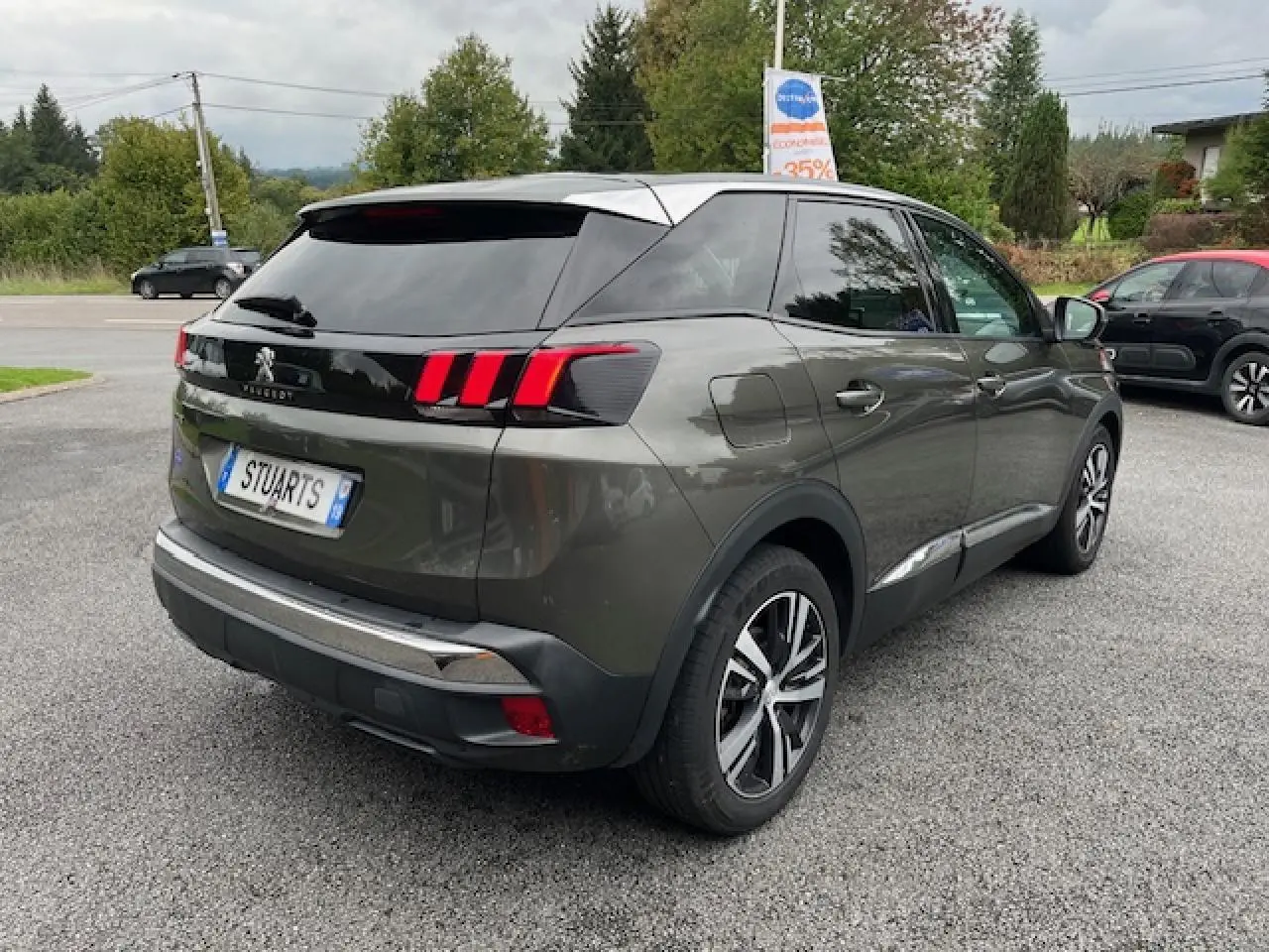 Peugeot 3008 gris amazonite vue 3/4 arrière droit, avec jantes alliage et feux arrière à griffes rouges.