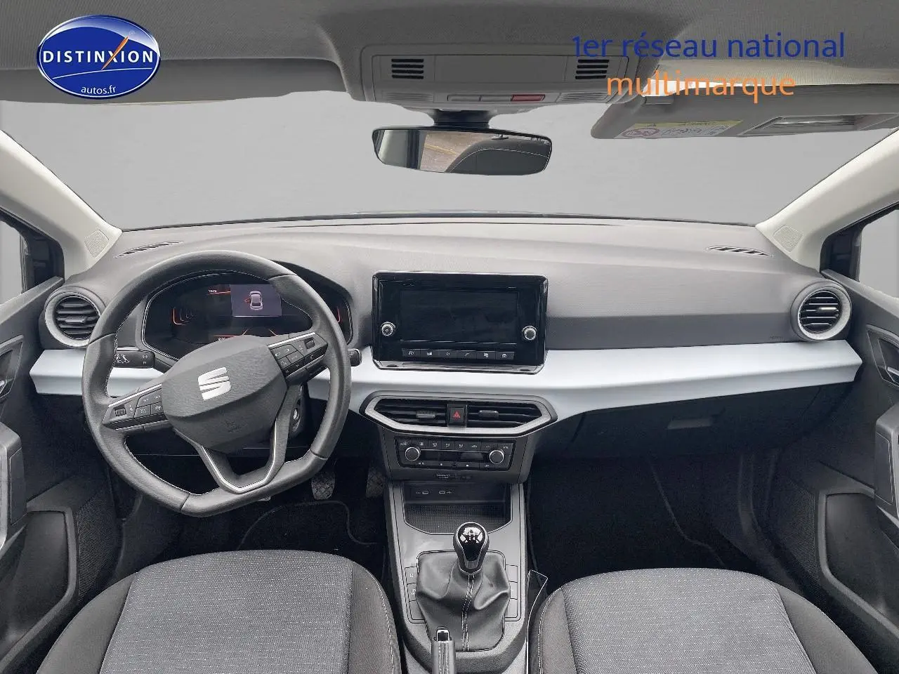 Vue intérieure avant de la SEAT Ibiza 1.0 TSI 95 Copa 2025, volant cuir méplat, tableau de bord noir et gris, boîte manuelle.