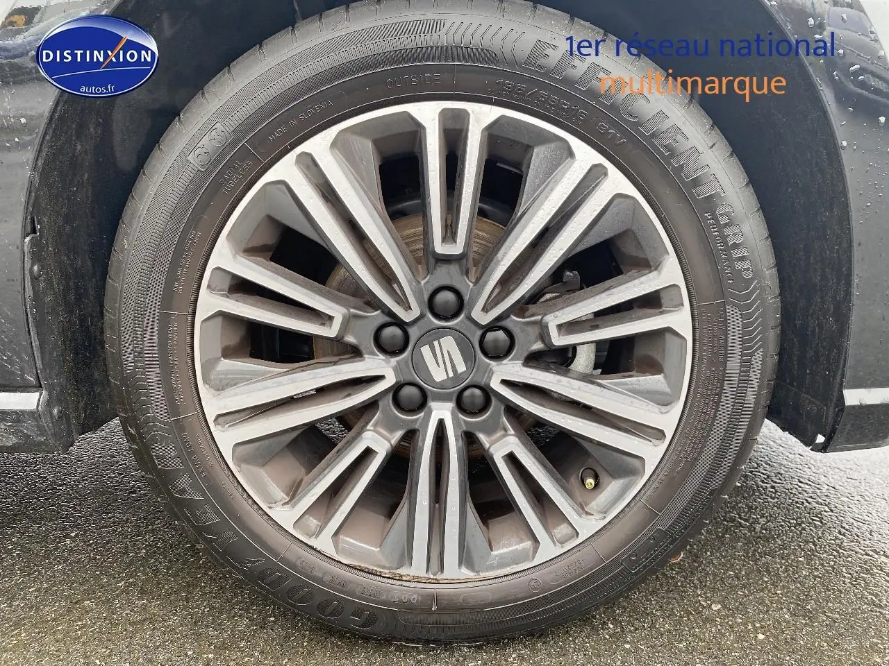 Gros plan sur la jante alliage gris foncé avec logo SEAT au centre, montée sur un pneu Goodyear.