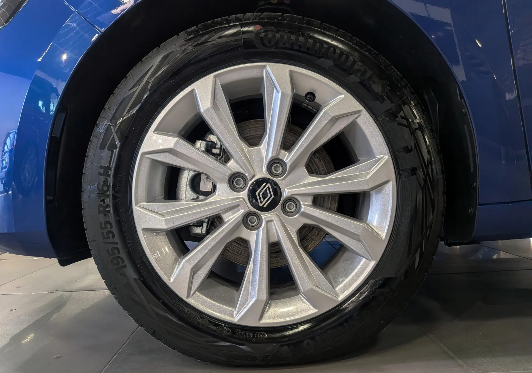 Gros plan sur la roue avant gauche de la Renault Clio V Bleu Iron avec jante alliage argentée et pneu Continental.