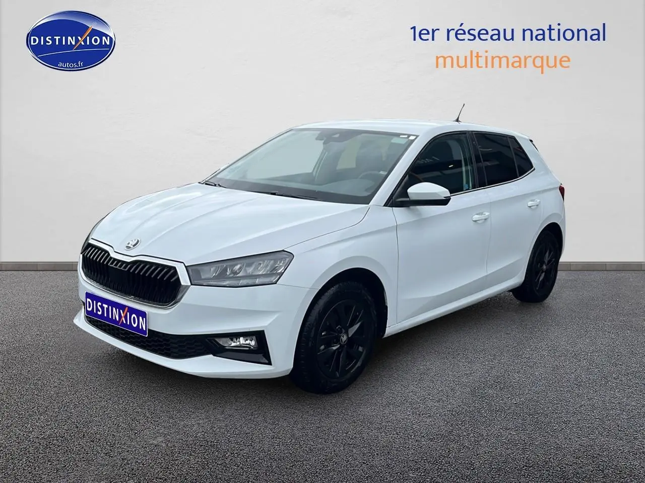 Skoda Fabia blanche vue en 3/4 avant droit avec jantes noires et vitres teintées sur fond neutre.