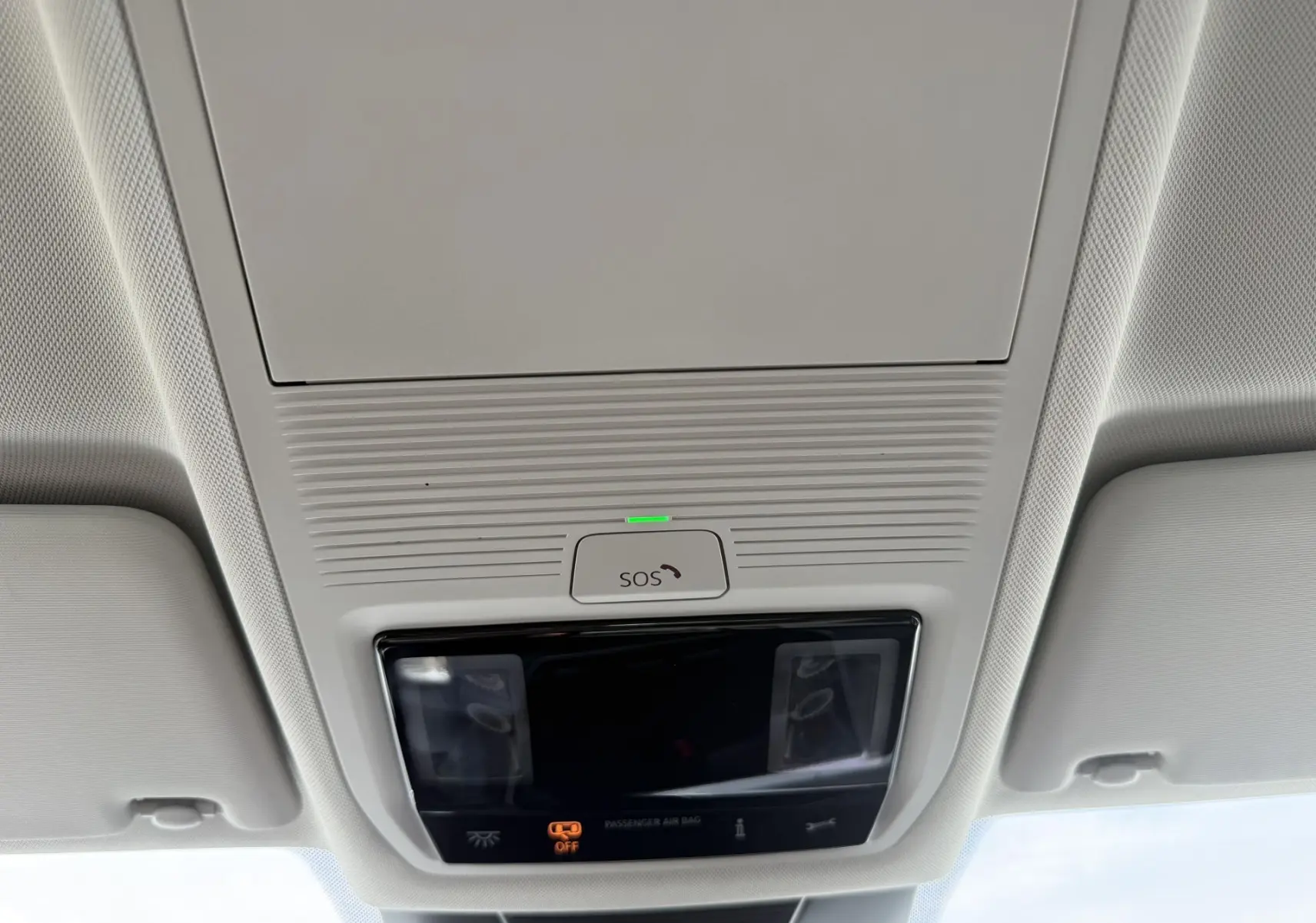 Plafonnier intérieur avec bouton SOS et éclairage, vue du toit d’un Volkswagen Tiguan noir 2025.