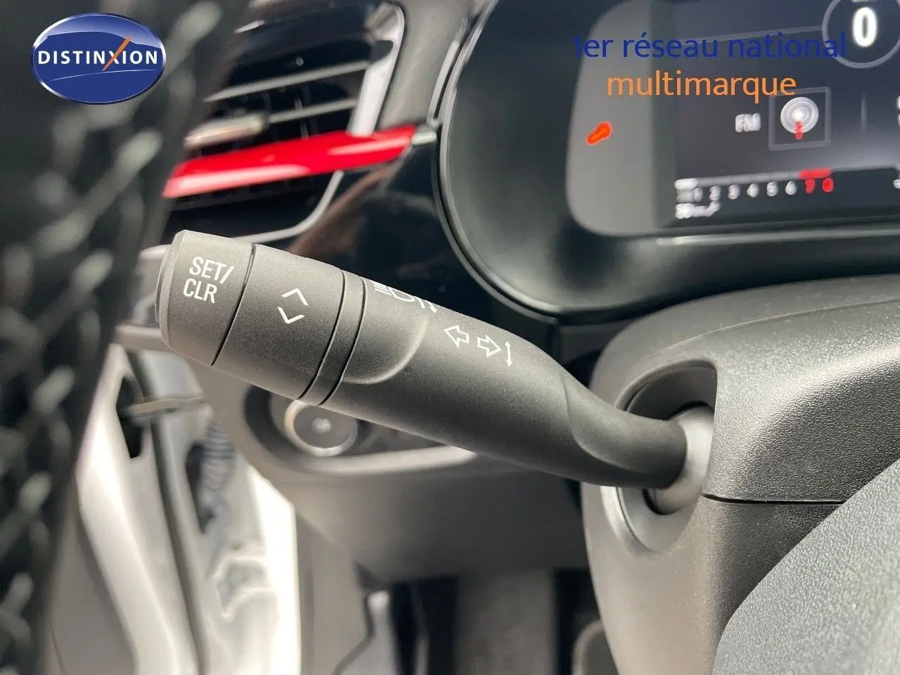 Gros plan sur la commande de clignotant à gauche du volant dans l'habitacle d'une Opel Corsa blanche 2022.