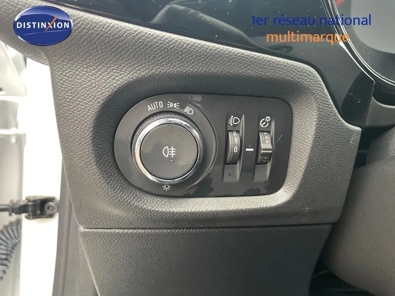 Gros plan sur le panneau de commande des phares à gauche du volant d'une Opel Corsa blanche 2022.