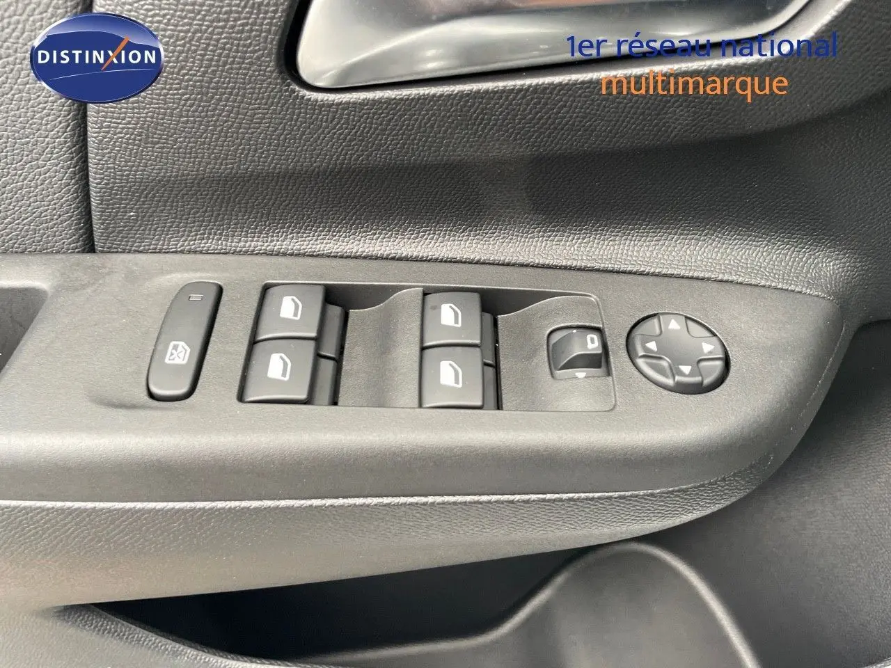 Gros plan sur les commandes de lève-vitres et réglages des rétroviseurs côté conducteur d'une Opel Corsa blanche 2022.