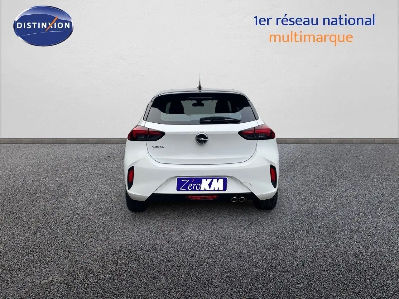 Vue arrière d'une Opel Corsa blanche 2022 avec double sortie d'échappement et feux arrière sombres sur fond neutre.