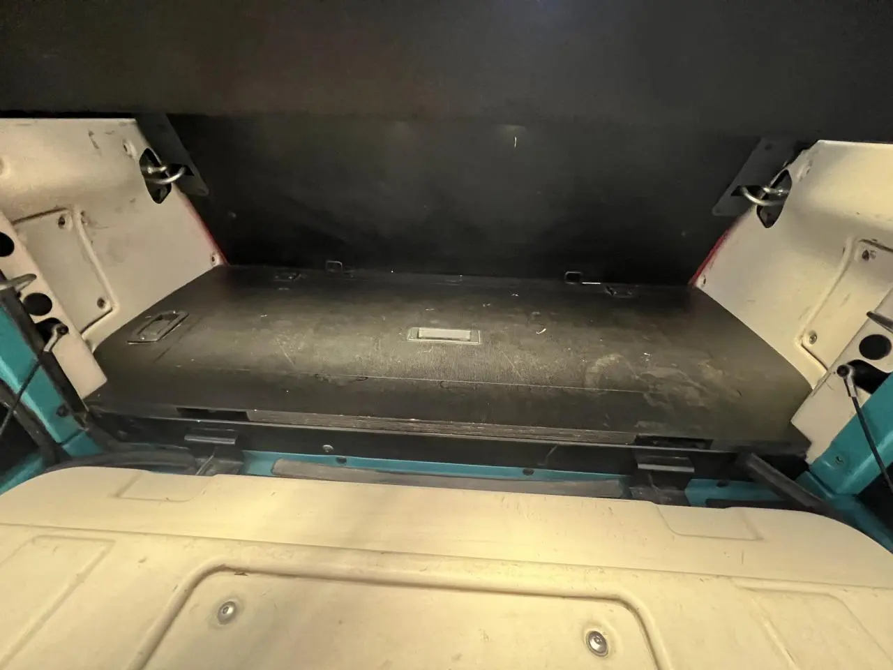 Vue rapprochée de la zone de coffre arrière du cabriolet Citroën E-MEHARI bleu clair de 2016, avec toit en toile replié.