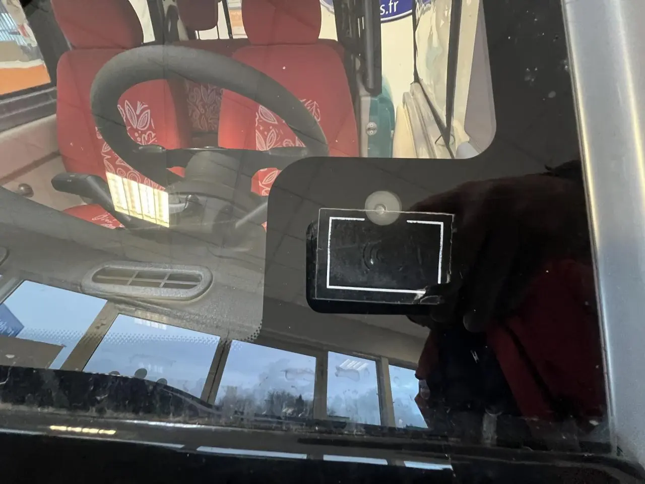 Vue intérieure du tableau de bord et volant du Citroën E-MEHARI cabriolet bleu clair avec sièges rouges à motifs.