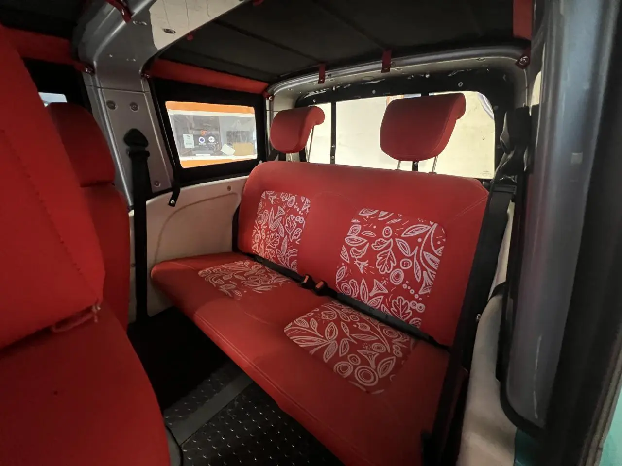 Vue intérieure côté droit du Citroën E-MEHARI cabriolet 2016, sièges rouges avec motifs blancs et toit en toile.