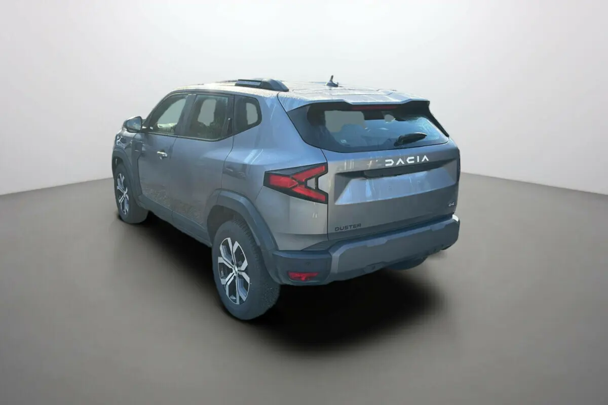 Vue 3/4 arrière gauche du Dacia Duster 2025 gris schiste, version Mild Hybrid 130 4x4 Expression avec jantes alliage.