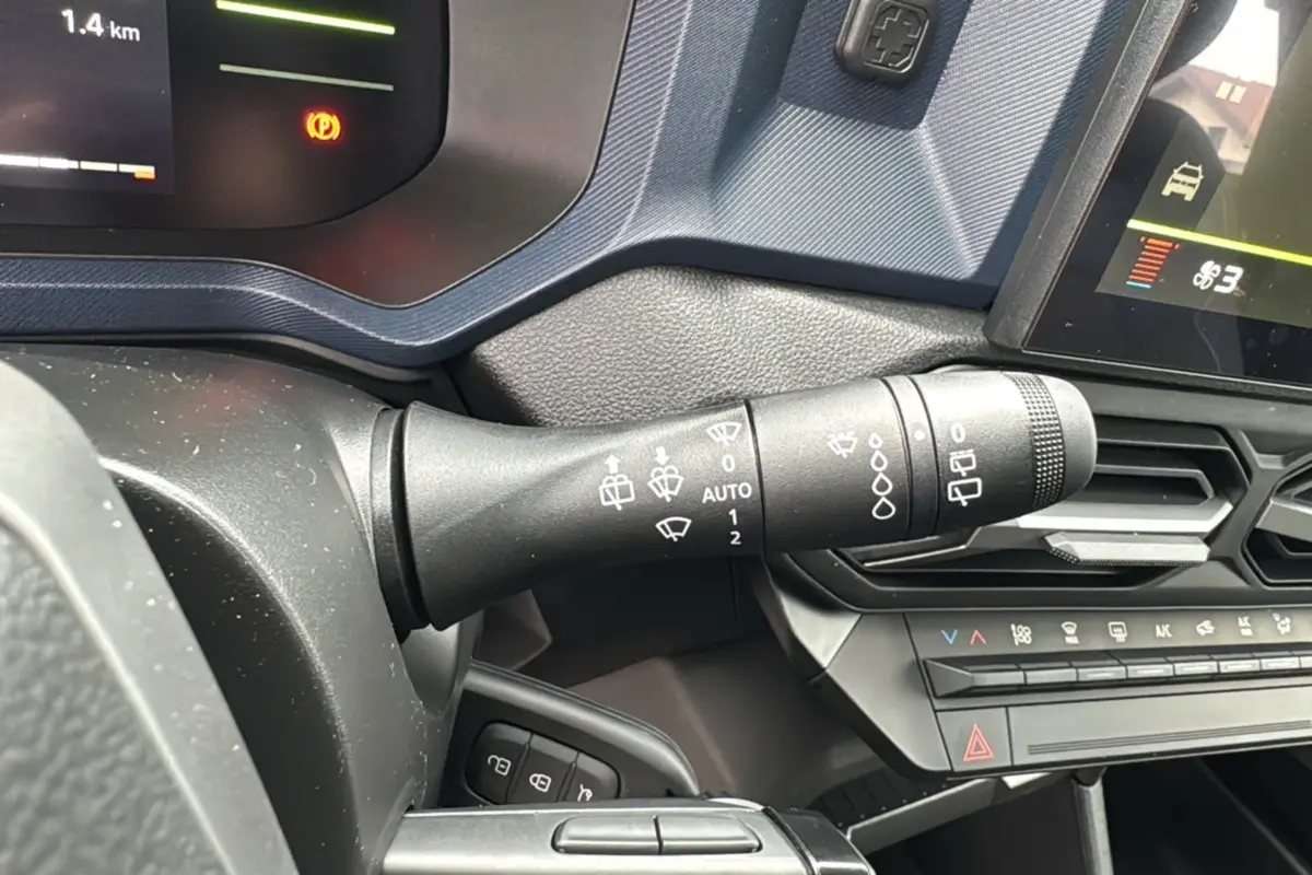 Gros plan sur la commande d'essuie-glace du tableau de bord du Dacia Duster 2025 gris schiste, version mild hybrid.