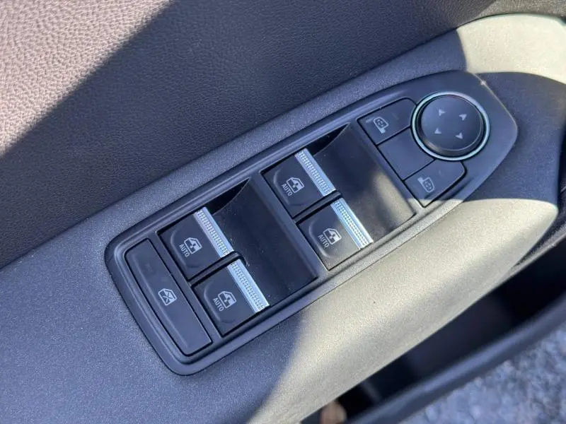 Panneau de commandes des vitres électriques côté conducteur du Renault Captur noir 2025, avec boutons auto et réglage des rétroviseurs.