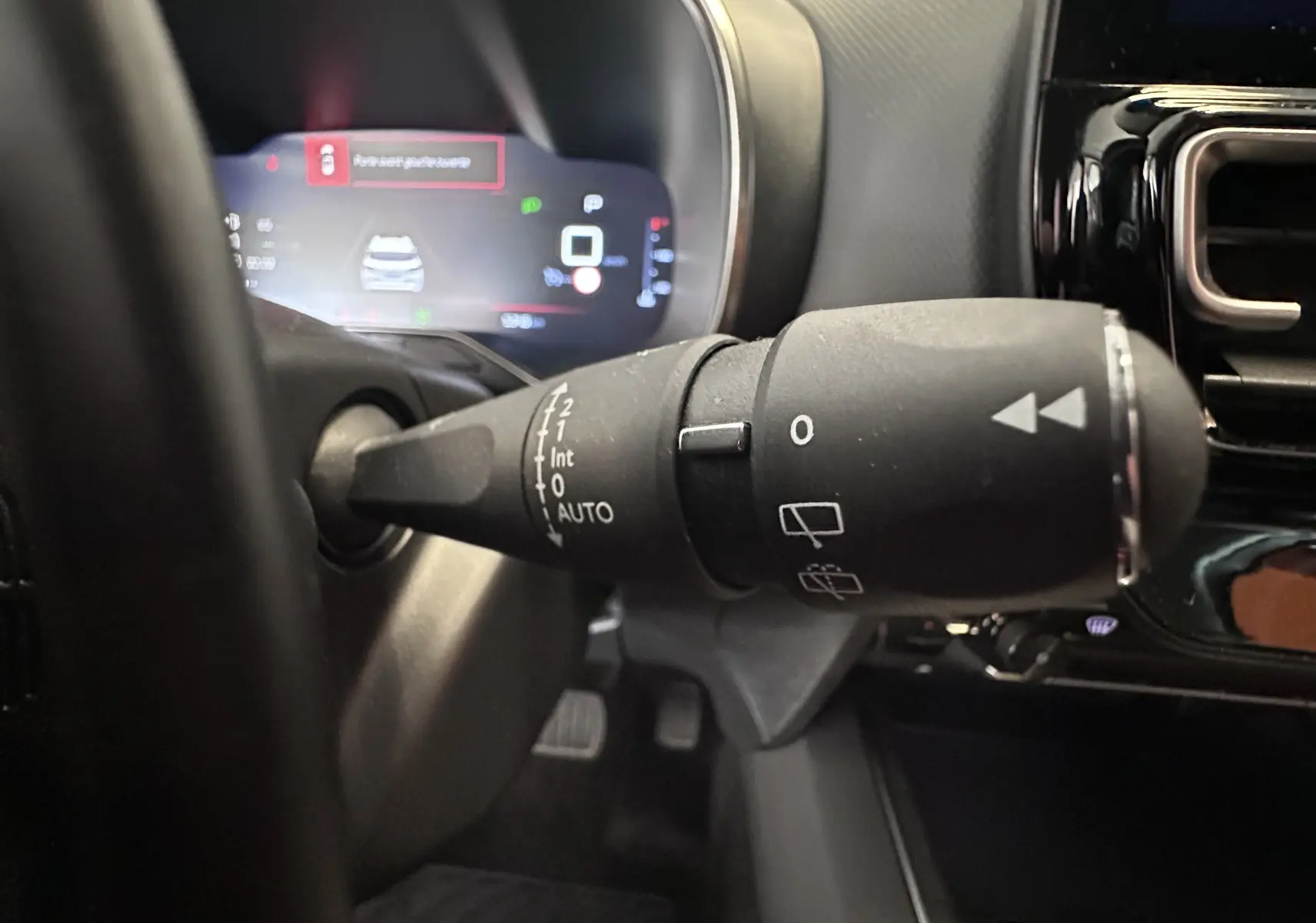 Gros plan sur la commande d’essuie-glace à gauche du volant dans l’habitacle gris du Citroën C5 Aircross 2024.