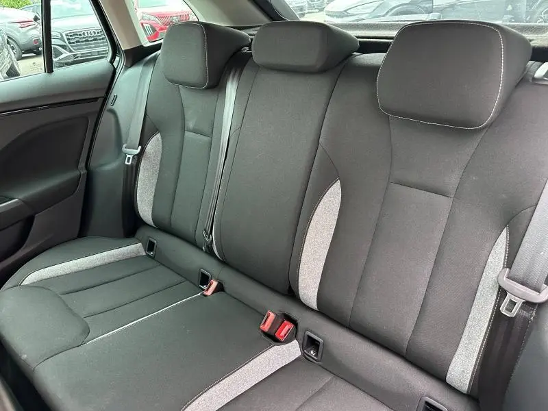 Vue intérieure arrière de la banquette tissu noir et gris clair de la Skoda Scala 2025, avec ceintures et appuie-têtes.