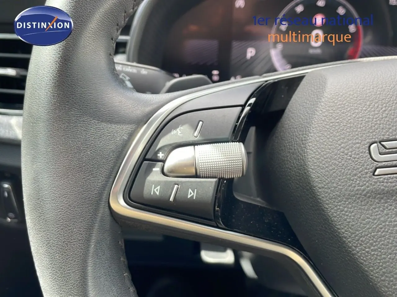 Gros plan sur le volant gris noir de la Skoda Scala 2025, avec commandes multimédia et molette texturée visible.