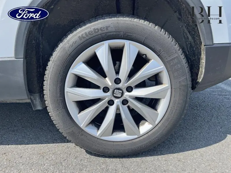Gros plan sur la roue avant droite du SEAT Ateca blanc Nevada Métal avec jante alu à dix branches.
