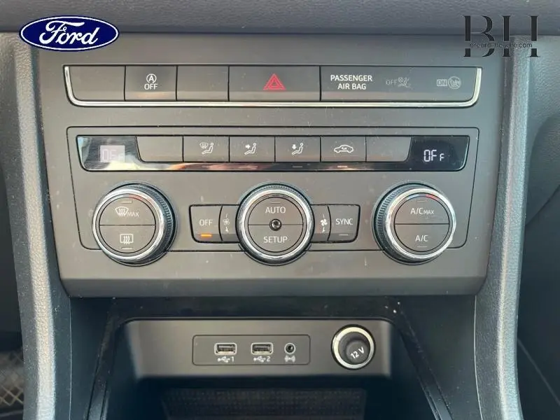 Vue rapprochée du tableau de bord central du SEAT Ateca blanc Nevada, mettant en valeur les commandes de climatisation et les prises USB.
