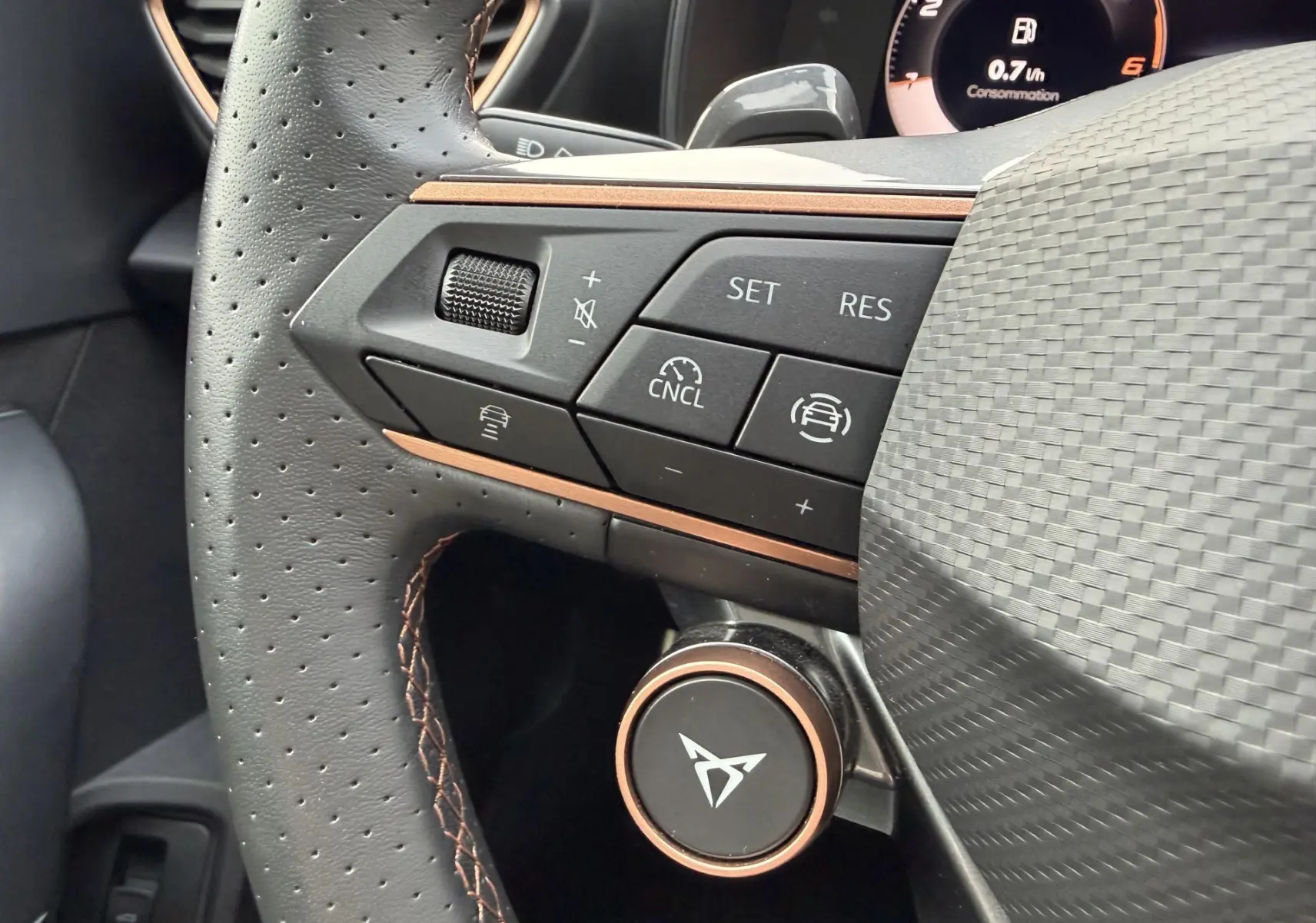 Gros plan sur le volant cuir perforé du CUPRA Formentor avec commandes multifonctions et logo CUPRA central.