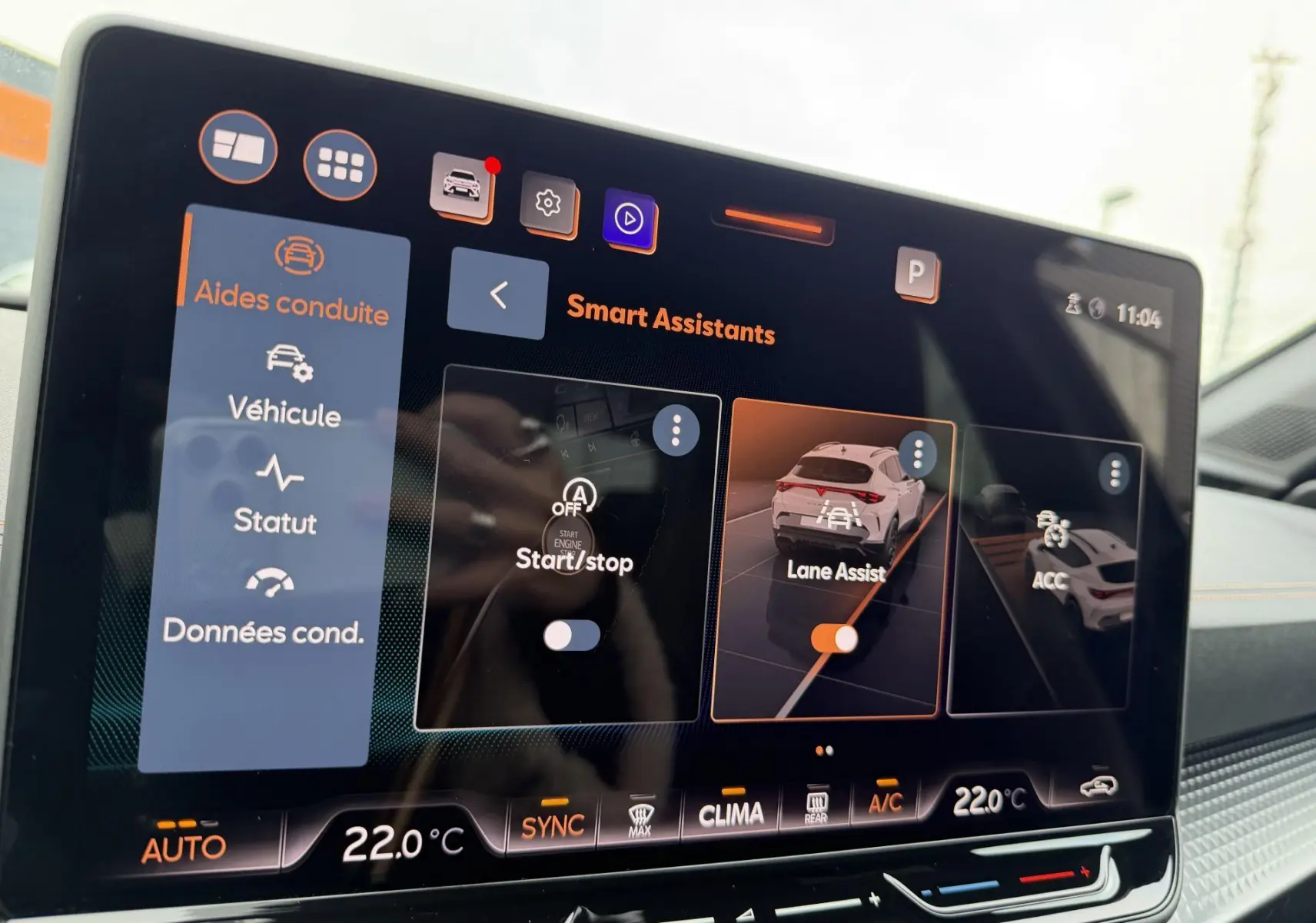 Écran tactile intérieur du CUPRA Formentor bleu montrant les options d’aides à la conduite avec interface moderne et claire.