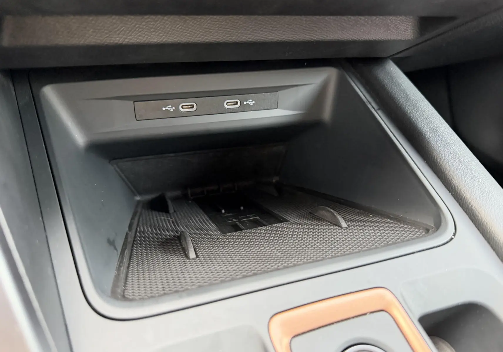 Gros plan sur la console centrale noire avec deux ports USB-C et un espace de rangement du CUPRA Formentor.