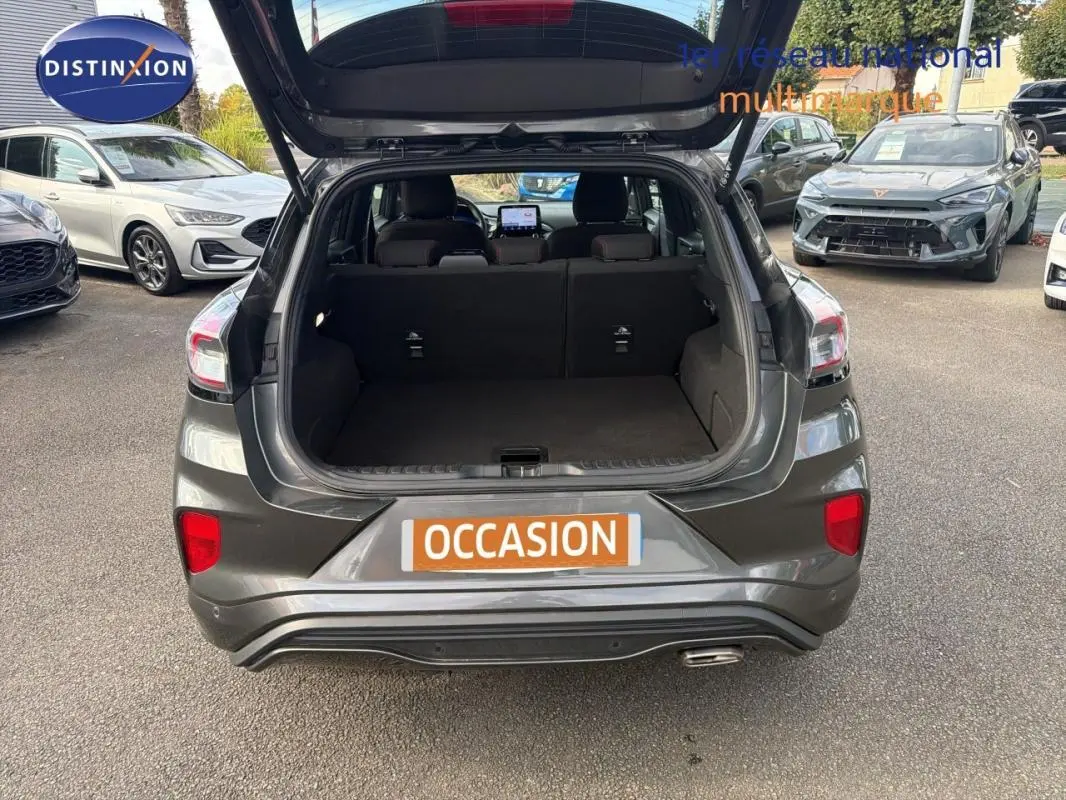Vue arrière d'un Ford Puma gris foncé 2022 avec coffre ouvert, montrant l'espace de chargement vide.