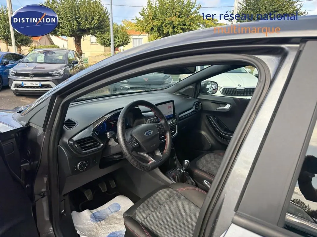 Vue intérieure côté conducteur du Ford Puma gris foncé 2022, avec volant, écran tactile et boîte manuelle visibles.
