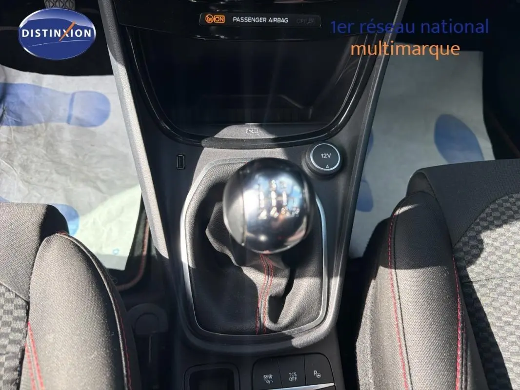 Vue intérieure centrée sur le levier de vitesses manuel et la console centrale du Ford Puma gris foncé 2022.