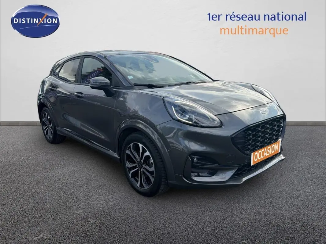 Ford Puma gris foncé vue 3/4 avant droit avec jantes alliage noires et calandre large noire.