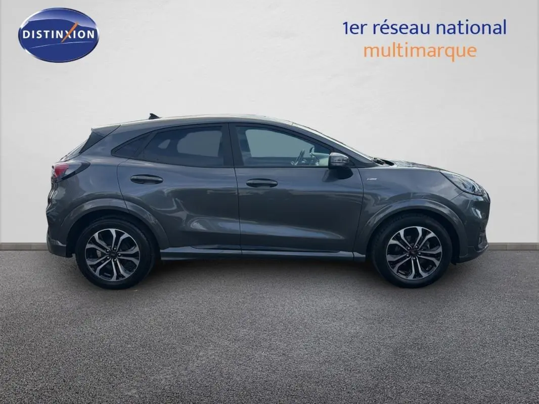 Vue de profil côté gauche d'un Ford Puma gris foncé avec jantes alliage 17 pouces sur fond neutre.