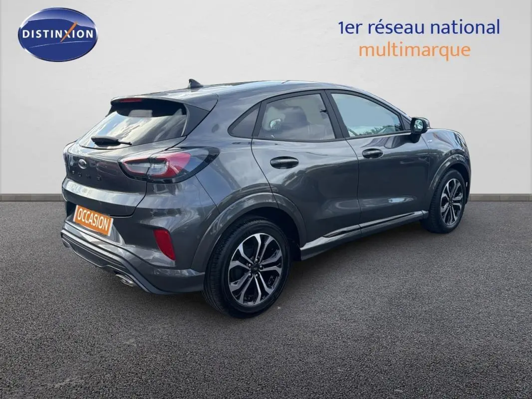 Ford Puma gris foncé vue 3/4 arrière droit, avec jantes alliage 17 pouces et feux arrière LED distinctifs.
