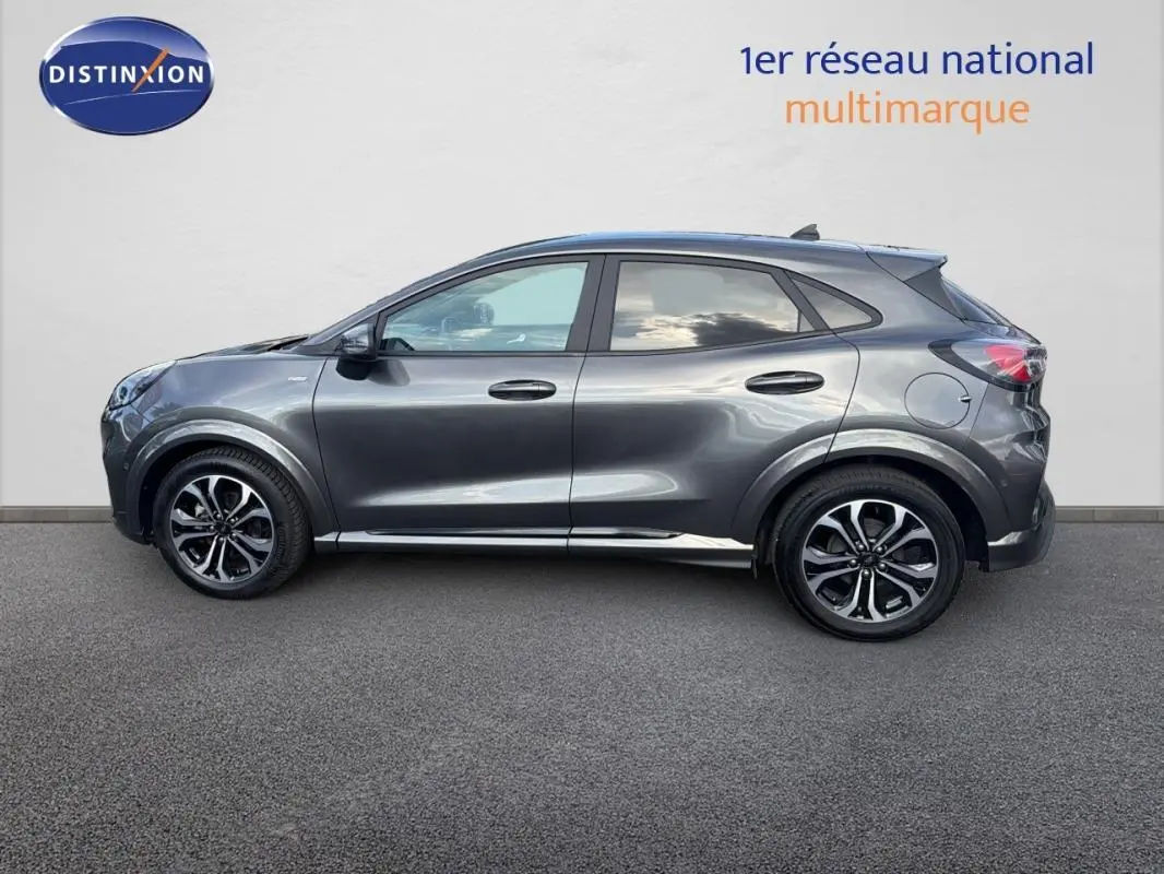 Vue de profil côté gauche d'un Ford Puma gris foncé avec jantes alliage 17 pouces sur fond neutre.