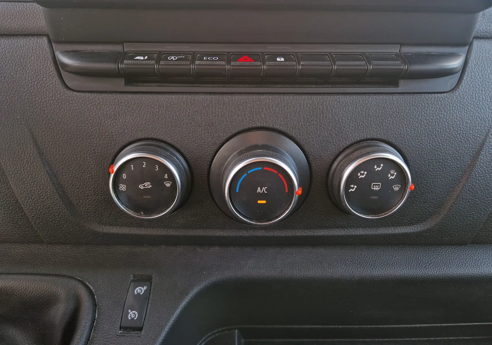 Gros plan sur les commandes de climatisation et boutons de fonction du tableau de bord du Renault Master Châssis Double Cabine blanc.