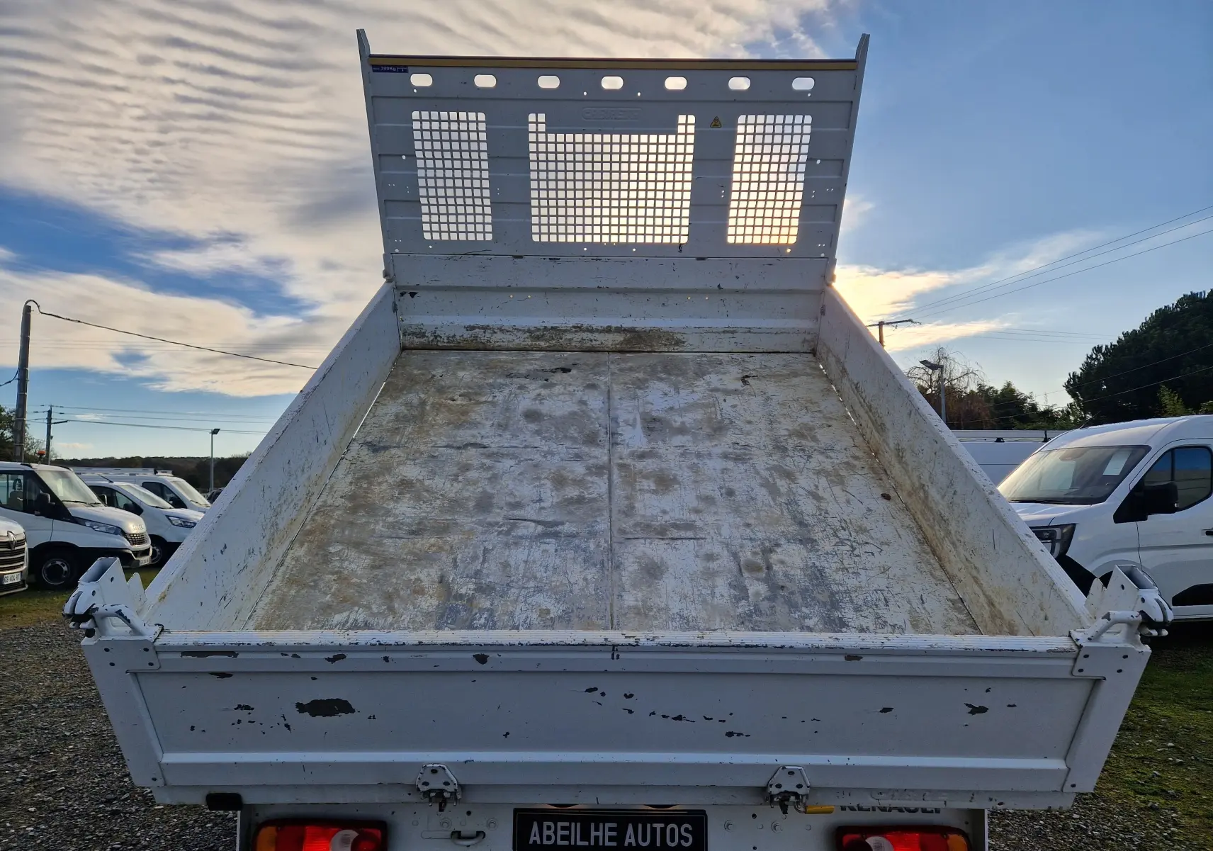 Vue arrière d'une benne blanche relevée du Renault Master Châssis Double Cab 2023 avec coffre et roues jumelées.