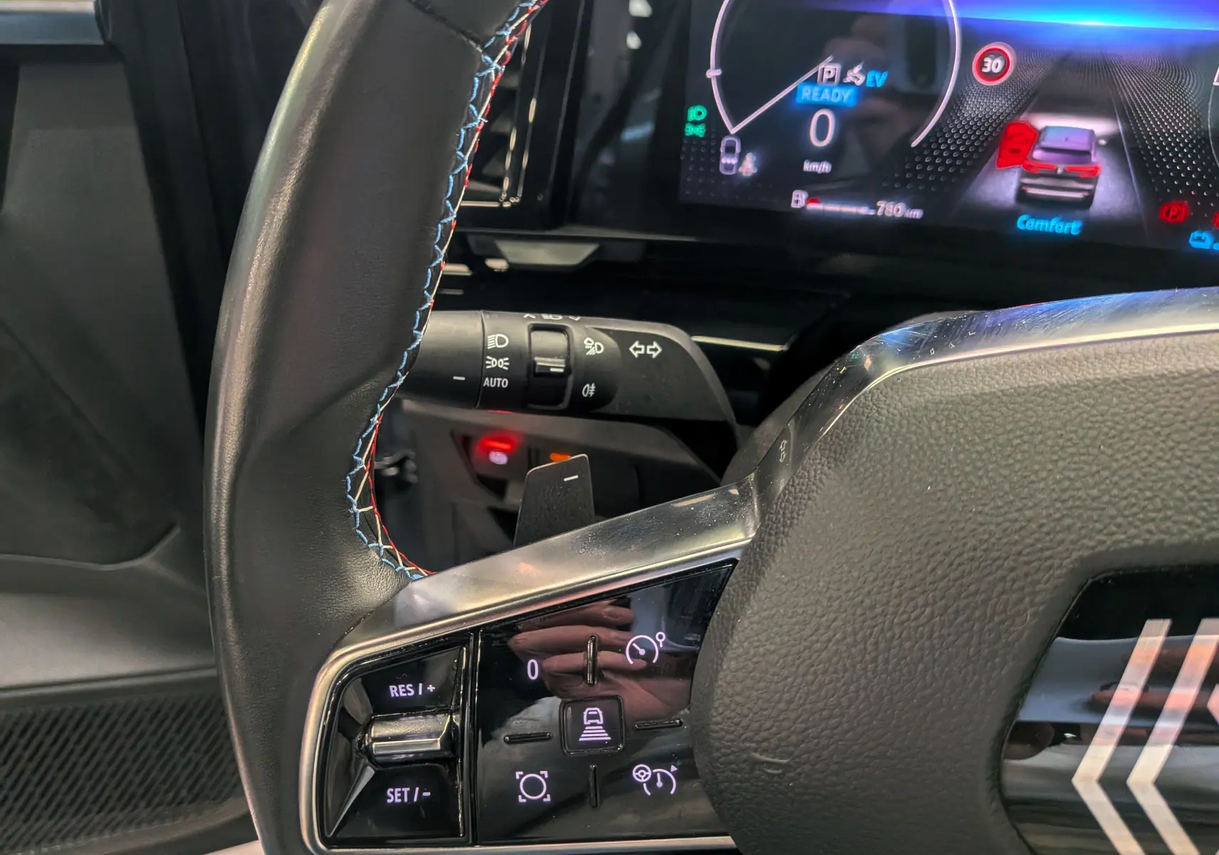 Gros plan sur le volant cuir avec surpiqûres tricolores et tableau de bord numérique du Renault Austral E-Tech hybride 2023.