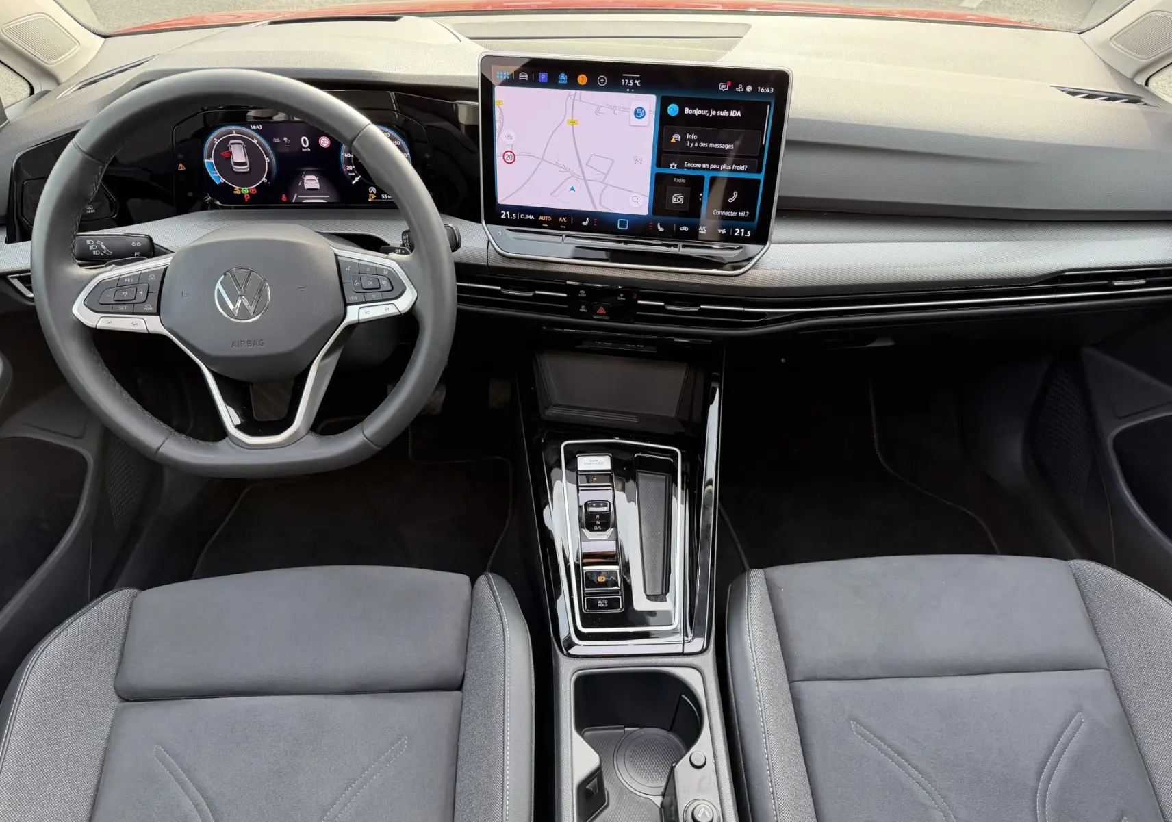 Vue intérieure avant de la Volkswagen Golf SW 2025, tableau de bord moderne avec écran tactile central et volant multifonction.
