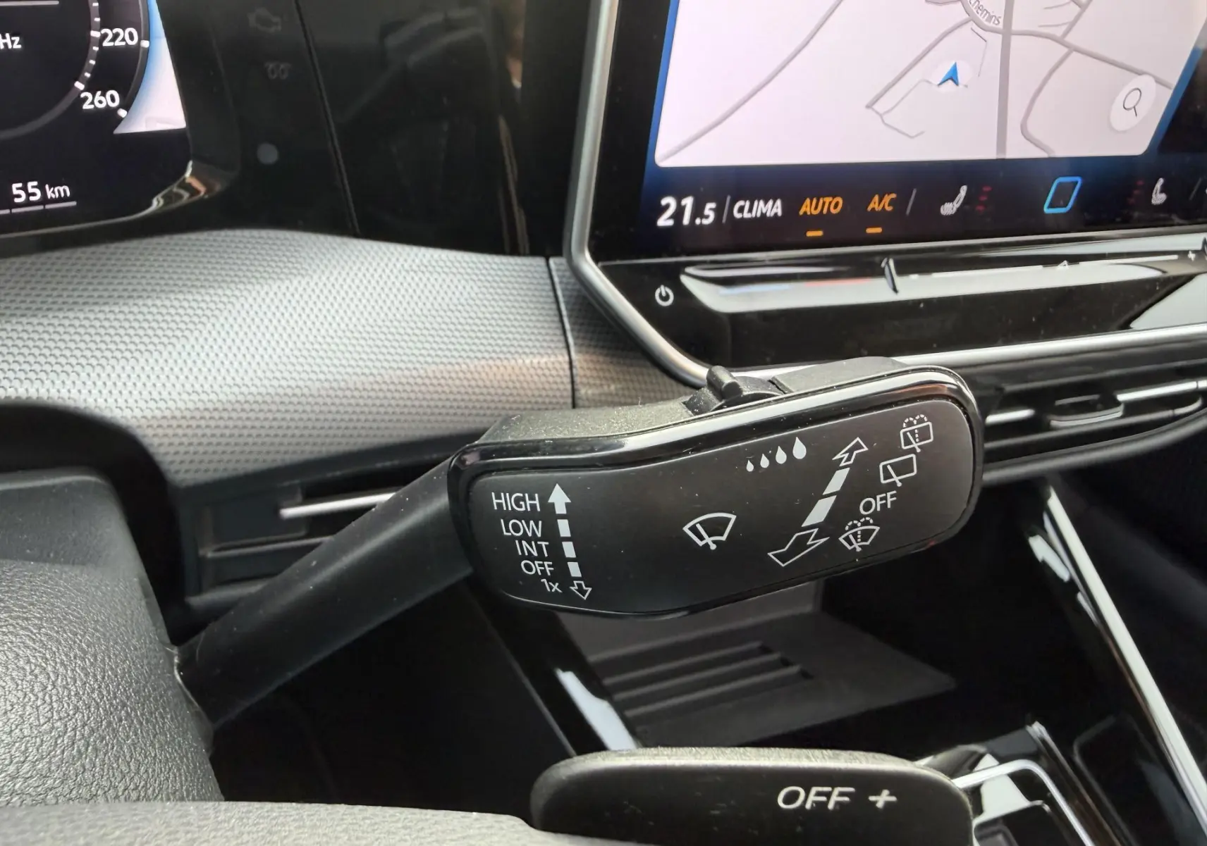 Gros plan sur la commande d’essuie-glace à gauche du volant dans l’habitacle de la Volkswagen Golf SW rouge 2025.