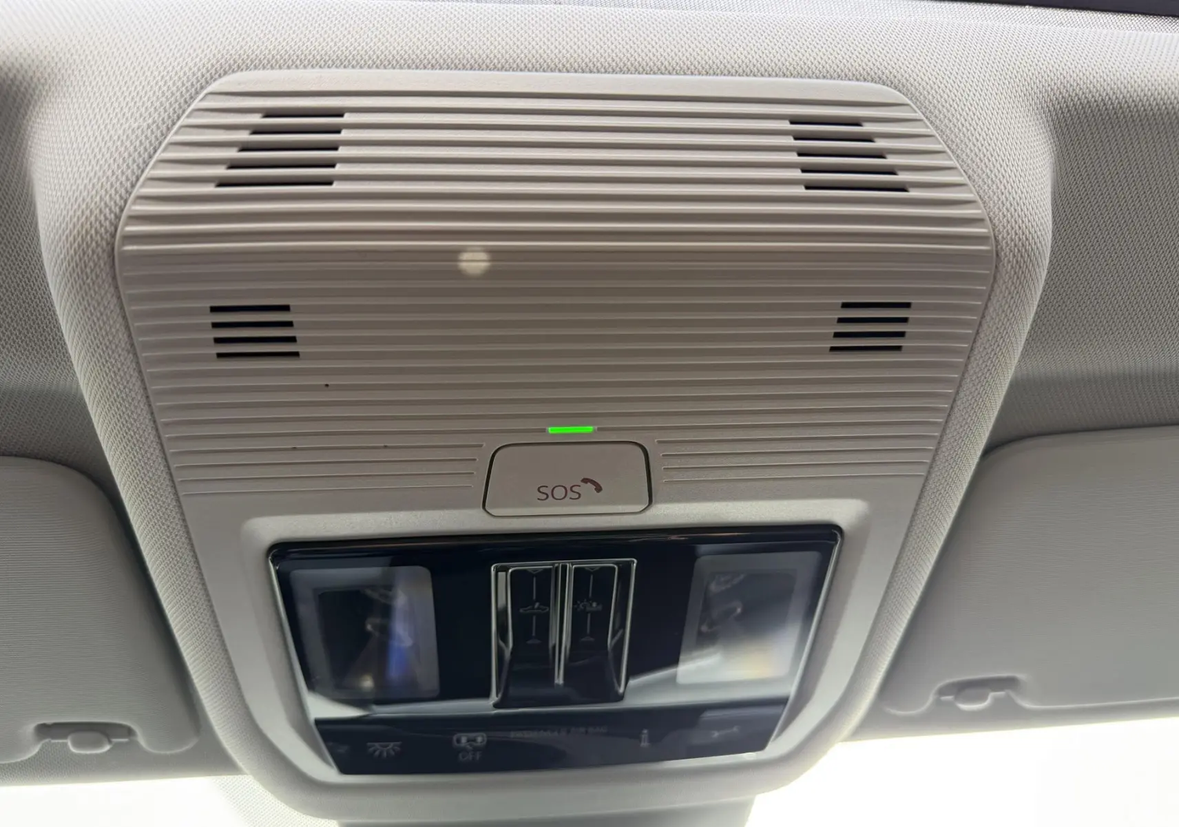 Plafonnier intérieur beige avec bouton SOS et commandes d'éclairage dans une Volkswagen Golf SW rouge de 2025.