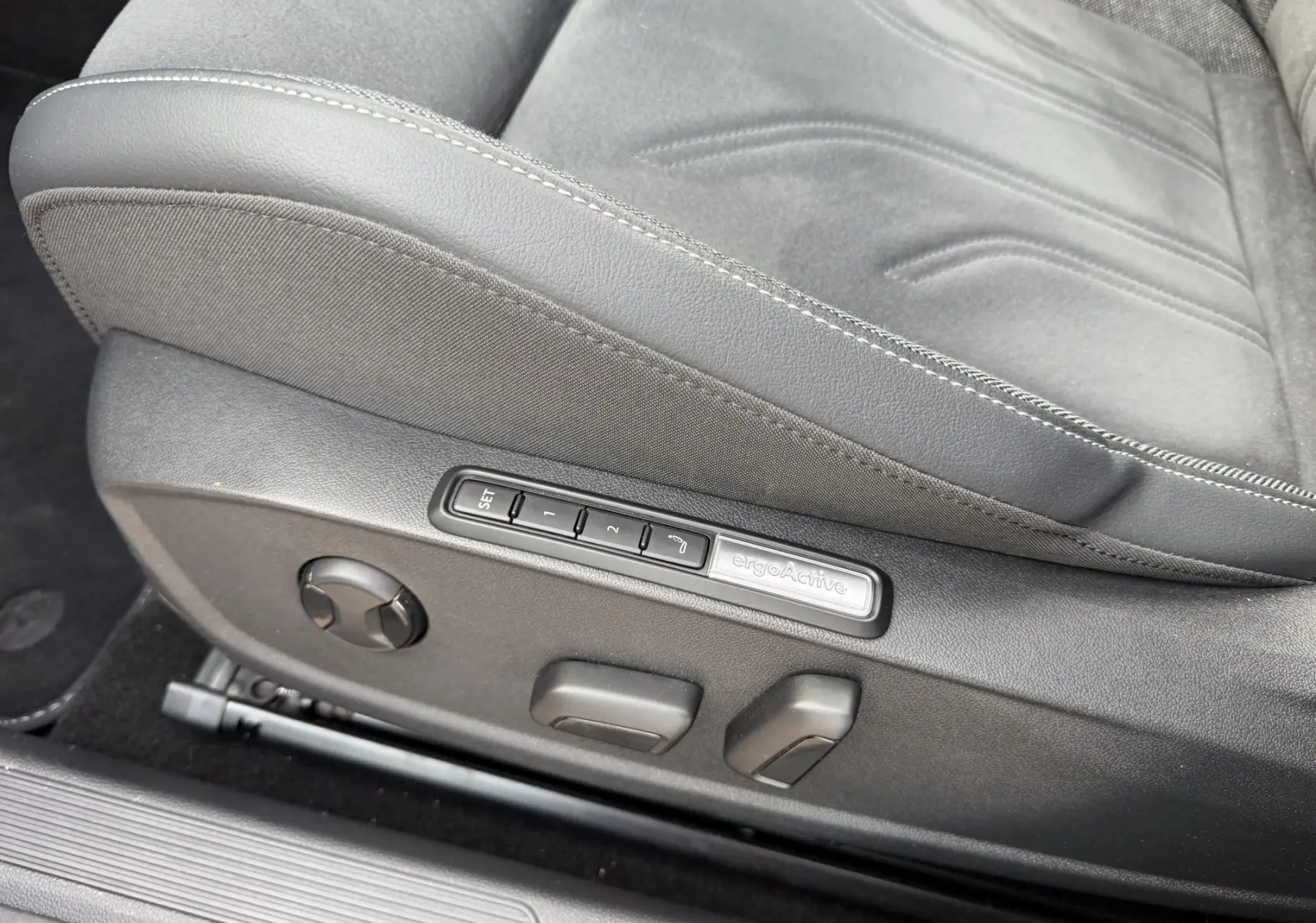 Gros plan sur le siège conducteur noir de la Volkswagen Golf SW 2.0 TDI avec commandes électriques ergoActive visibles.