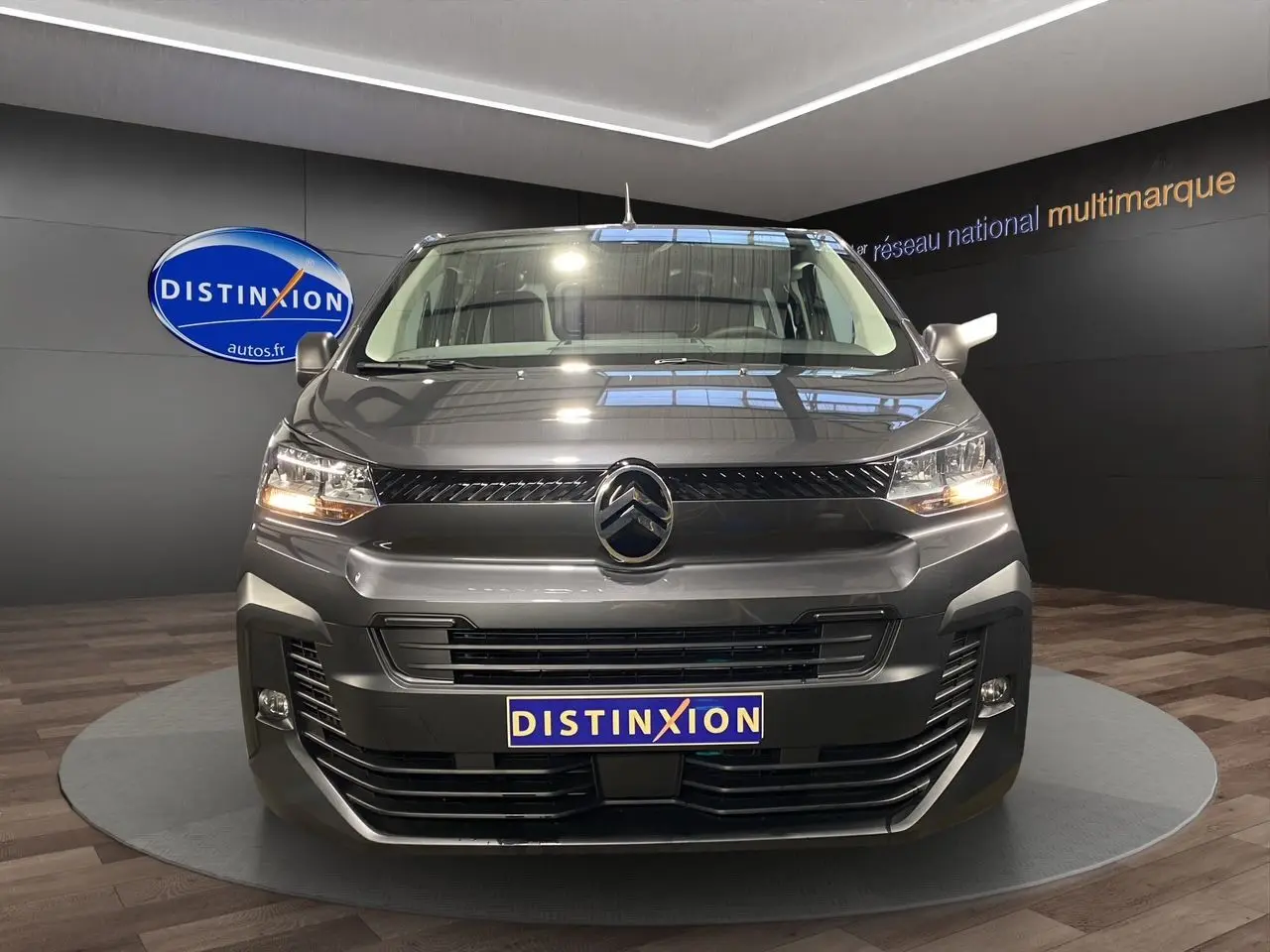 Vue frontale d'un Citroën Jumpy Fourgon gris platinium avec phares allumés et logo distinctif au centre.