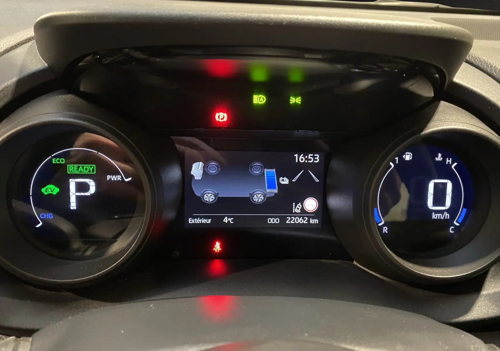 Tableau de bord numérique de Toyota Yaris Cross hybride, affichant vitesse, mode éco et indicateurs d'alerte.