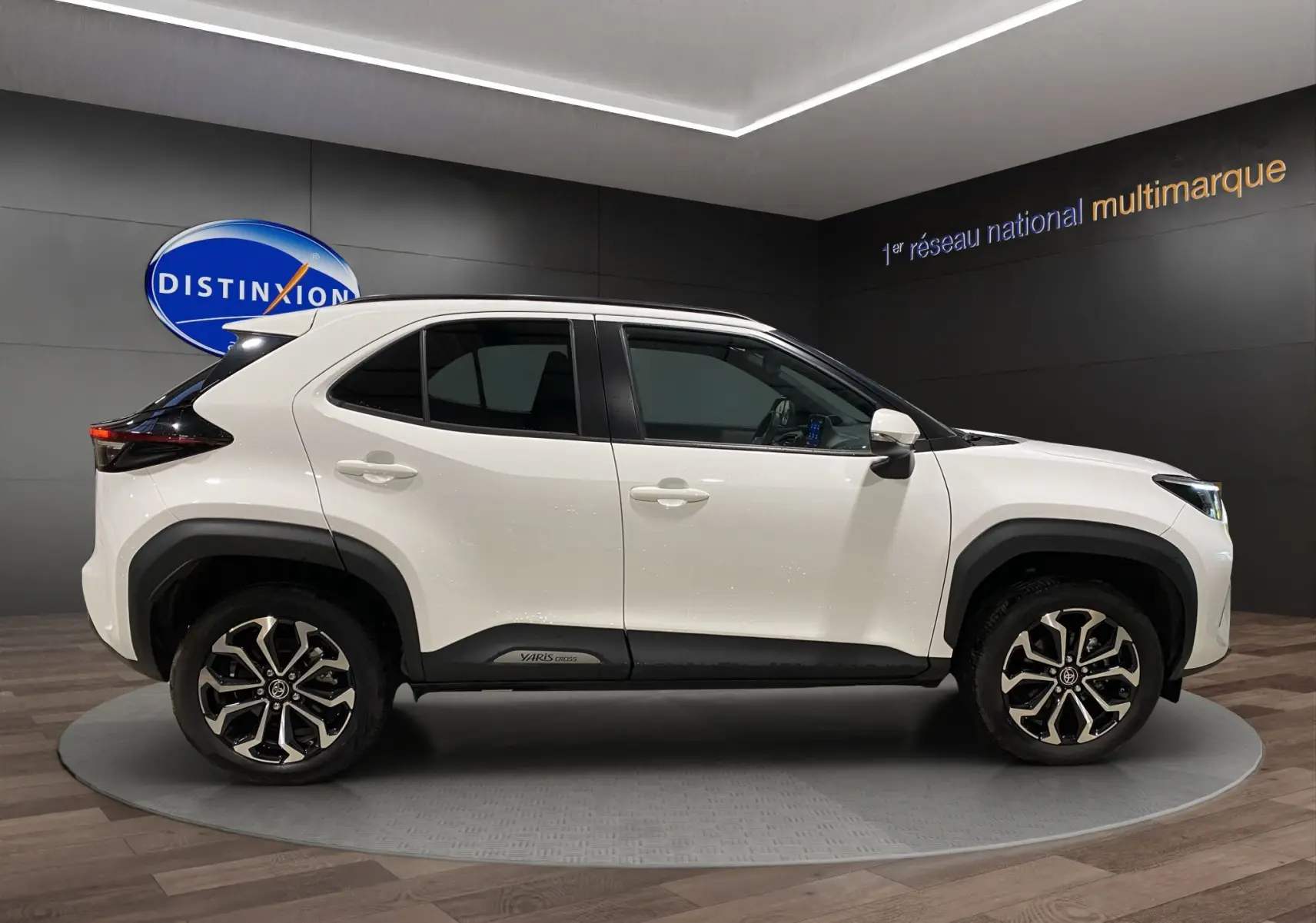 Profil côté gauche d'une Toyota Yaris Cross blanche 2023 avec jantes alliage 17 pouces et détails noirs contrastants.