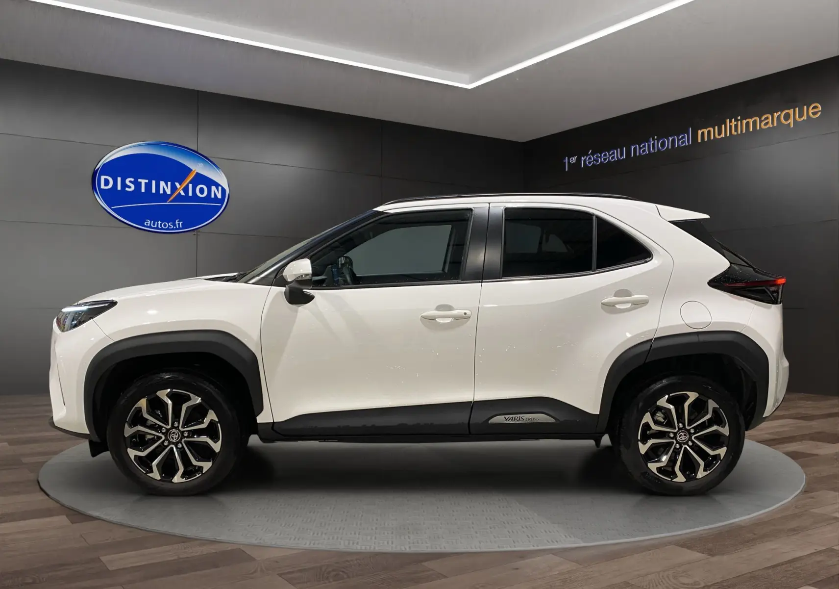 Profil droit d'une Toyota Yaris Cross blanche avec jantes alu 17 pouces et protections noires sur les passages de roues.